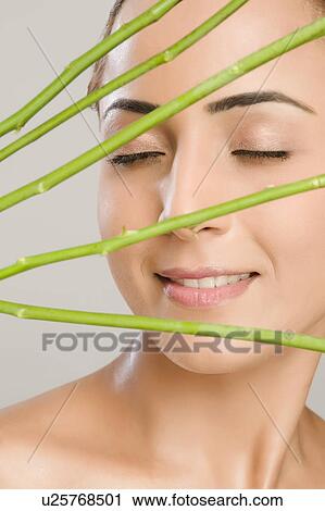 Close-up of a woman with rose stems in front of her face View Large Photo Image Stock Image - Close-up of a woman with rose stems in front of her face. Fotosearch