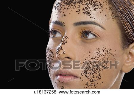 Stock Photo - Close-up of a woman with tea leaves on her face. Fotosearch