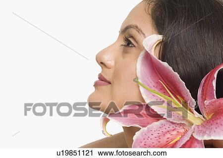Stock Image - Close-up of a woman with Tiger Lily flower. Fotosearch