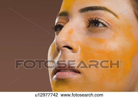 Close-up of a woman with turmeric on her face View Large Photo Image Stock Image - Close-up of a woman with turmeric on her face. Fotosearch