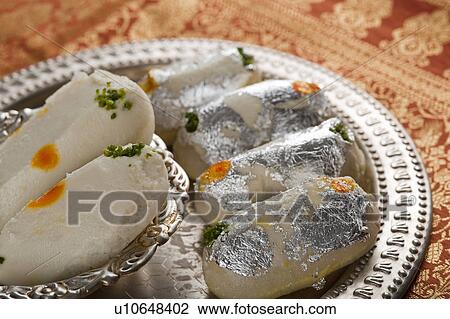Stock Image - Close-up of cham cham a traditional Indian sweet made from chhena (cottage cheese) and khoya (solid milk). Fotosearch