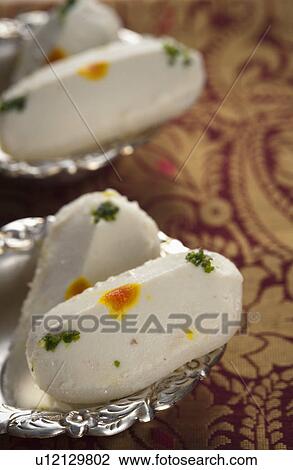 Close-up of cham cham a traditional Indian sweet made from chhena (cottage cheese) and khoya (solid milk) View Large Photo Image Stock Image - Close-up of cham cham a traditional Indian sweet made from chhena (cottage cheese) and khoya (solid milk). Fotosearch