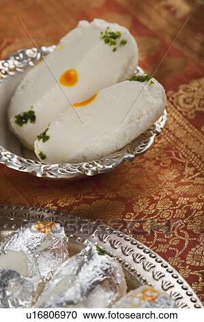 Stock Image - Close-up of cham cham a traditional Indian sweet made from chhena (cottage cheese) and khoya (solid milk). Fotosearch