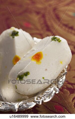 Stock Photo - Close-up of cham cham a traditional Indian sweet made from chhena (cottage cheese) and khoya (solid milk). Fotosearch