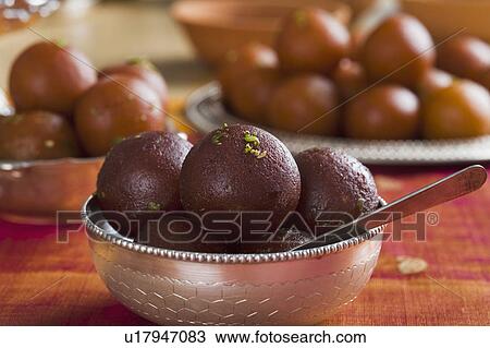 Stock Image - Close-up of gulab jamuns (a popular traditional Indian sweet) in a bowl. Fotosearch