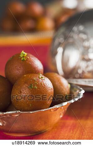Stock Photo - Close-up of gulab jamuns (a popular traditional Indian sweet) in a bowl. Fotosearch