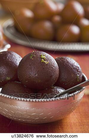 Close-up of gulab jamuns (a popular traditional Indian sweet) in a bowl View Large Photo Image Stock Photograph - Close-up of gulab jamuns (a popular traditional Indian sweet) in a bowl. Fotosearch