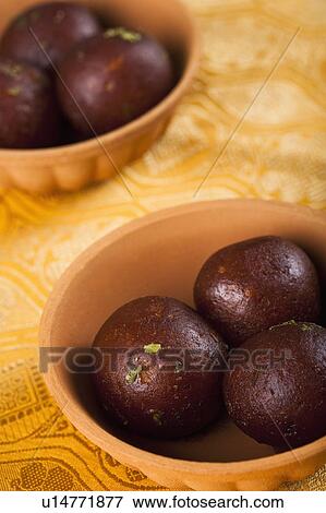 Stock Photo - Close-up of two bowls of gulab jamuns (a popular traditional Indian sweet). Fotosearch