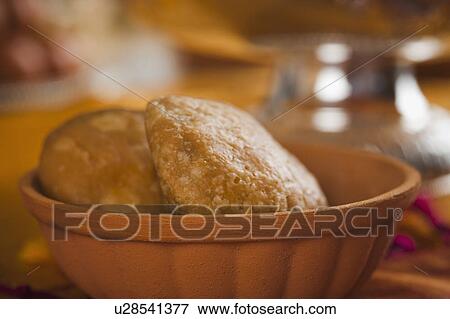 Stock Photo - Close-up of two kachories (deep fried traditional Indian snack) in a bowl. Fotosearch