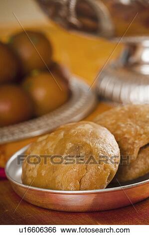 Stock Photograph - Close-up of two kachories (deep fried traditional Indian snack) in a bowl. Fotosearch