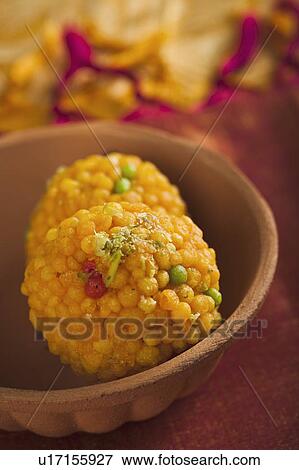 Stock Photo - Close-up of two motichoor laddoos (a popular traditional Indian sweet) in a bowl. Fotosearch
