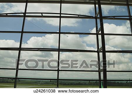 Stock Photo - Clouds viewed through an airport lounge window, Cork Airport, Cork, County Cork, Republic of Ireland. Fotosearch