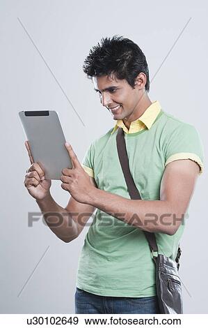 College student using a digital tablet View Large Photo Image Stock Photo - College student using a digital tablet. Fotosearch