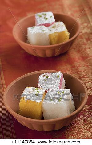 Picture - Colorful coconut burfi in bowls. Fotosearch
