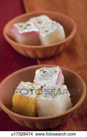 Picture - Colorful coconut burfi in bowls. Fotosearch