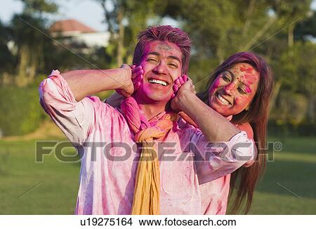 Picture - Couple celebrating Holi in a garden. Fotosearch
