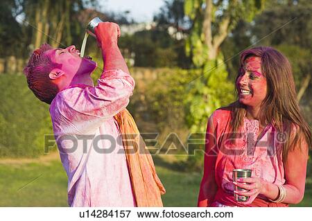 Stock Photo - Couple celebrating Holi with glass of bhang. Fotosearch
