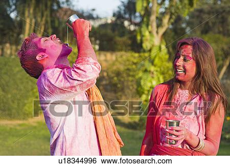 Couple celebrating Holi with glass of bhang View Large Photo Image Stock Photograph - Couple celebrating Holi with glass of bhang. Fotosearch