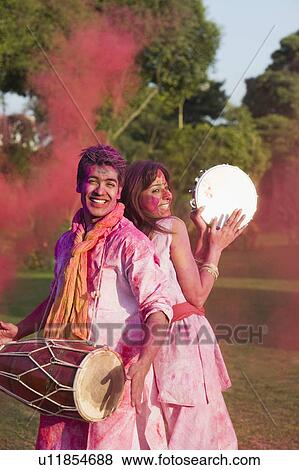 Couple celebrating Holi with musical instruments in a garden View Large Photo Image Stock Photo - Couple celebrating Holi with musical instruments in a garden. Fotosearch