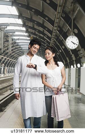 Couple checking the time at subway station View Large Photo Image Stock Photo - Couple checking the time at subway station. Fotosearch
