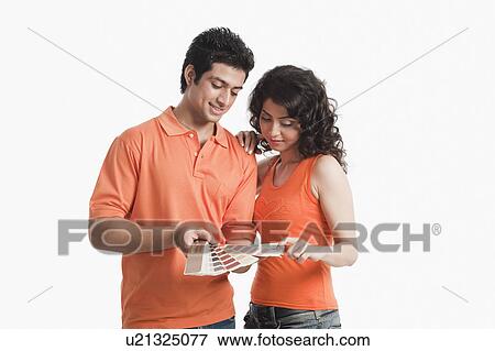 Stock Photo - Couple choosing color from color swatches for their house. Fotosearch