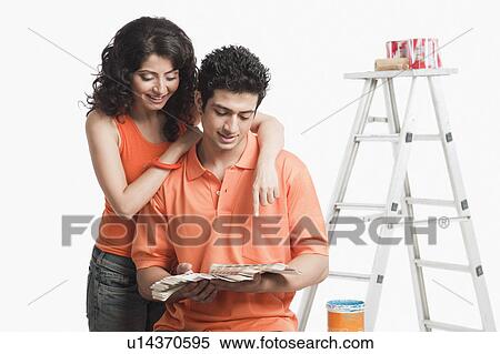 Couple choosing color from color swatches for their house View Large Photo Image Stock Photography - Couple choosing color from color swatches for their house. Fotosearch