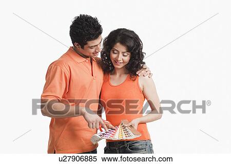 Stock Photography - Couple choosing color from color swatches for their house. Fotosearch