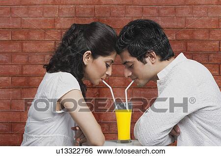 Stock Photograph - Couple drinking juice together. Fotosearch
