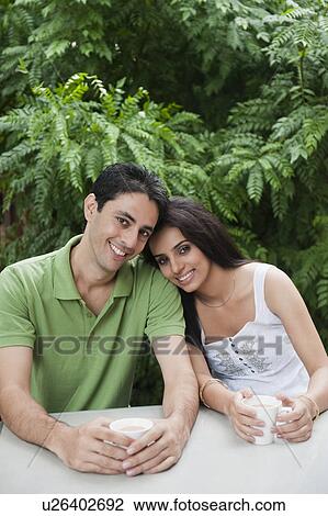 Stock Image - Couple drinking tea in a lawn. Fotosearch