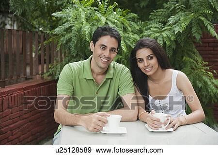 Stock Photo - Couple drinking tea in a lawn. Fotosearch