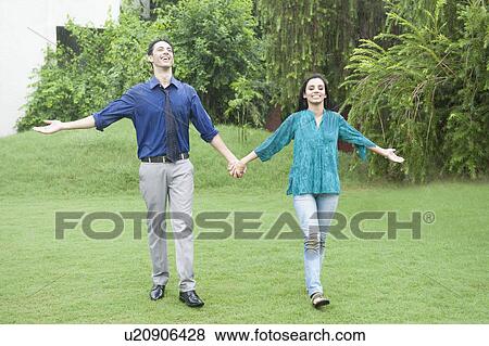 Stock Photo - Couple enjoying rain in a park. Fotosearch