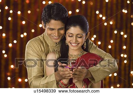 Couple holding an oil lamp together View Large Photo Image Stock Photo - Couple holding an oil lamp together. Fotosearch