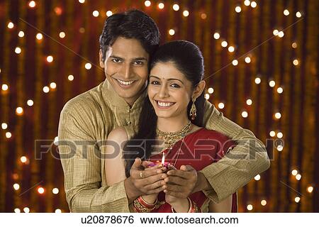 Couple holding an oil lamp together View Large Photo Image Stock Photograph - Couple holding an oil lamp together. Fotosearch