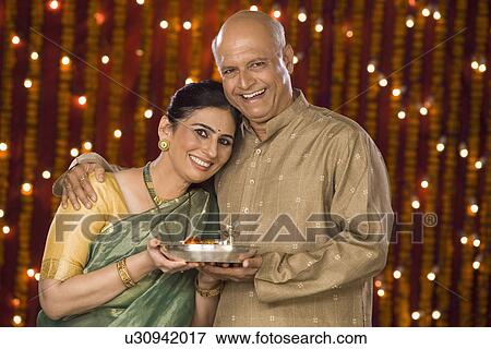 Couple holding pooja thali View Large Photo Image Stock Photo - Couple holding pooja thali. Fotosearch