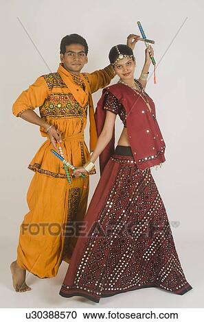 Stock Image - Couple performing dandiya. Fotosearch