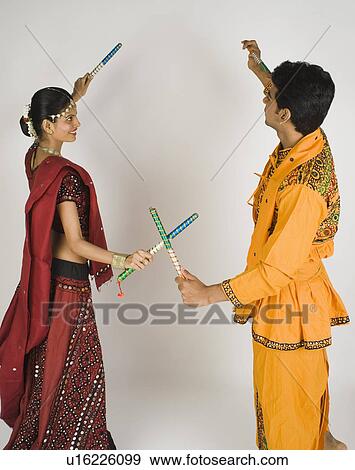 Couple performing dandiya View Large Photo Image Stock Photo - Couple performing dandiya. Fotosearch