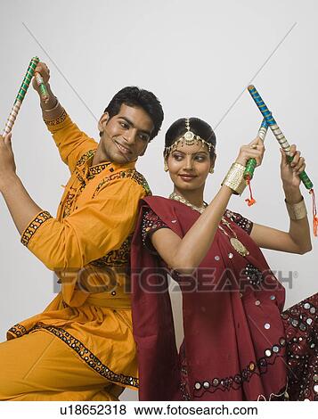 Stock Photo - Couple performing dandiya. Fotosearch