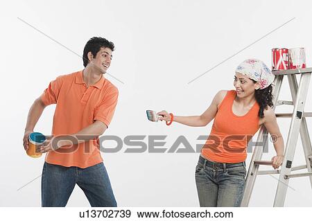 Couple playing with paints in their house View Large Photo Image Stock Photo - Couple playing with paints in their house. Fotosearch