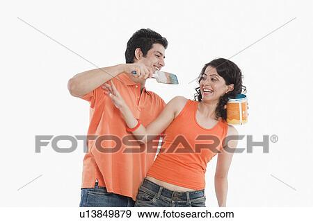 Stock Photo - Couple playing with paints in their house. Fotosearch