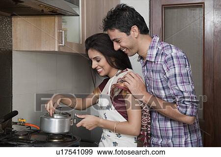 Stock Photo - Couple preparing food in the kitchen. Fotosearch