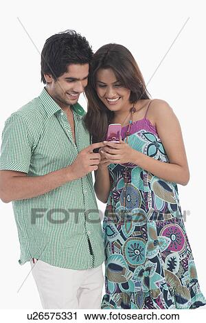 Couple reading SMS on a mobile phone View Large Photo Image Stock Image - Couple reading SMS on a mobile phone. Fotosearch