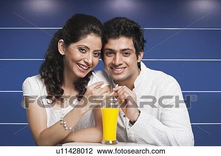Couple sharing juice from a glass View Large Photo Image Stock Image - Couple sharing juice from a glass. Fotosearch