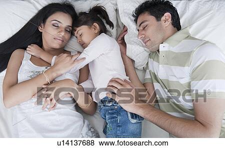 Couple sleeping with their daughter View Large Photo Image Stock Photo - Couple sleeping with their daughter. Fotosearch