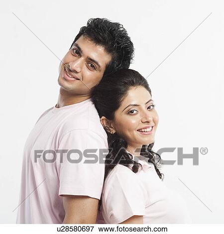 Couple standing back to back and smiling View Large Photo Image Stock Photo - Couple standing back to back and smiling. Fotosearch