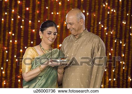 Stock Photograph - Couple standing with a pooja thali. Fotosearch