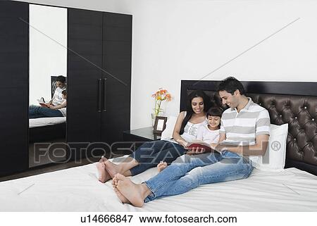 Couple teaching their daughter in the bedroom View Large Photo Image Stock Photo - Couple teaching their daughter in the bedroom. Fotosearch