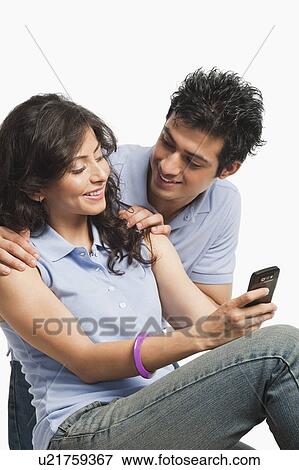 Couple text messaging on a mobile phone View Large Photo Image Stock Photo - Couple text messaging on a mobile phone. Fotosearch