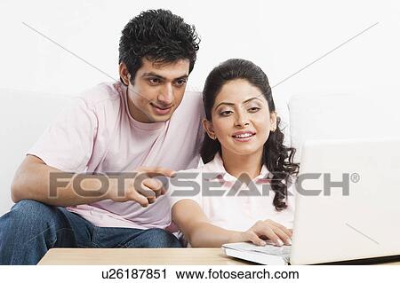 Couple using a laptop View Large Photo Image Stock Image - Couple using a laptop. Fotosearch