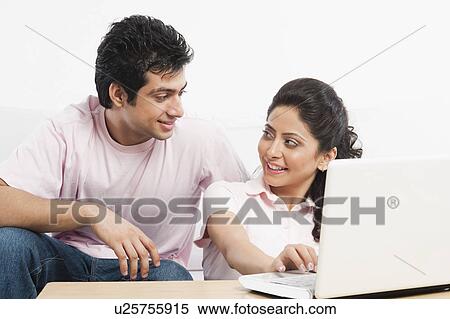 Couple using a laptop View Large Photo Image Stock Photography - Couple using a laptop. Fotosearch