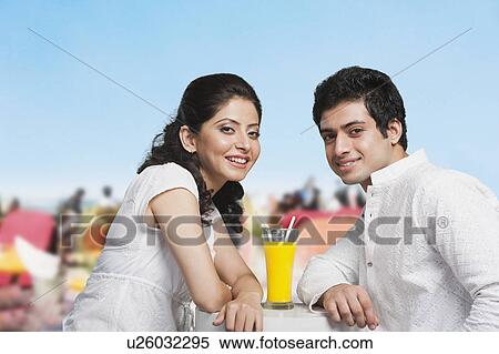 Couple with a glass of juice at a restaurant View Large Photo Image Stock Photography - Couple with a glass of juice at a restaurant. Fotosearch